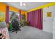 Bright bedroom with yellow walls, desk, and decor features a chair and eye-catching purple curtains at 15052 Sw 43Rd Terrace Rd, Ocala, FL 34473