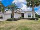 Charming single-story home with a well-manicured lawn and lush tropical landscaping, including mature palm trees at 15857 Sw 11Th Terrace Rd, Ocala, FL 34473