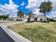 Inviting home featuring mature palm trees, a paver driveway, and a well-maintained lawn and landscaping at 15857 Sw 11Th Terrace Rd, Ocala, FL 34473