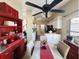 Bright eat-in kitchen featuring a decorative red hutch and a ceiling fan with lights over the dining table at 15857 Sw 11Th Terrace Rd, Ocala, FL 34473