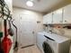 Laundry room featuring a washer and dryer with white cabinets and a drying rack at 15857 Sw 11Th Terrace Rd, Ocala, FL 34473