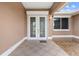 Elegant double-door entry with decorative glass inserts and charming exterior lighting at 1621 Yellow Brick Rd, Astor, FL 32102