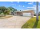 Beautiful single-story home with a large driveway, well-maintained lawn, and neutral tan paint at 1621 Yellow Brick Rd, Astor, FL 32102