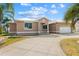 Charming single story home showcasing stucco and white trim, plus a large, patterned concrete driveway at 1621 Yellow Brick Rd, Astor, FL 32102