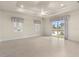 Bright living room features tile flooring, tray ceiling with fan, and sliding glass doors to a water view at 1621 Yellow Brick Rd, Astor, FL 32102