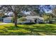 Charming single-story home with a well-manicured front yard, lush green lawn, and mature trees providing shade at 1712 Ne 40Th Ave, Ocala, FL 34470
