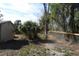 Backyard with wooden fence, greenery, and partial view of a wooden shed or structure at 3560 Sw 24Th Avenue Rd, Ocala, FL 34471