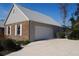 Side exterior view of a home featuring a spacious driveway leading to a two-car garage and a mix of brick and siding at 3560 Sw 24Th Avenue Rd, Ocala, FL 34471