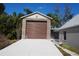 Two-story garage featuring brick exterior, concrete driveway, and open garage door at 3560 Sw 24Th Avenue Rd, Ocala, FL 34471