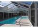 An enclosed swimming pool with a large pool deck, jacuzzi, and nice lighting at 3560 Sw 24Th Avenue Rd, Ocala, FL 34471