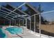 View of a screened pool area with a pool, a handrail and a lush green grass area at 3560 Sw 24Th Avenue Rd, Ocala, FL 34471