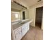 Bright bathroom featuring a vanity with white cabinets and a large mirror at 3940 Sw 138Th Pl, Ocala, FL 34473