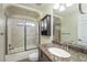 This bathroom features a tiled shower with glass doors, marble countertop, and a stylish vanity at 4604 Se 33Rd Pl, Ocala, FL 34480