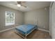 A cozy bedroom is brightened by a window with a blue mattress over a metal frame bed and plush carpet at 4604 Se 33Rd Pl, Ocala, FL 34480