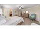 Spacious bedroom with ceiling fan, dresser, accent chair, and access to a bathroom at 5094 Se 89Th St, Ocala, FL 34480