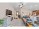 Bright living room features a large gray sofa, modern decor, and a ceiling fan at 5094 Se 89Th St, Ocala, FL 34480