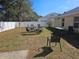 Backyard with a white fence, lawn chairs, fire pit, and sparse dry grass at 5155 Sw 39Th St, Ocala, FL 34474