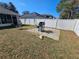 Backyard with a white fence, patio with grill, and sparse dry grass at 5155 Sw 39Th St, Ocala, FL 34474