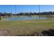 View of the Community tennis and basketball courts surrounded by green grass and a pond at 5155 Sw 39Th St, Ocala, FL 34474