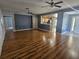 Open-concept living room with wood flooring, ceiling fans, and view to kitchen area at 5155 Sw 39Th St, Ocala, FL 34474