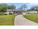 Charming home featuring a teal door, well-manicured lawn, and an attached two car garage at 6 Cherry Drive Ln, Ocala, FL 34472