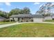 Charming home featuring a teal door, well-manicured lawn, and an attached two car garage at 6 Cherry Drive Ln, Ocala, FL 34472