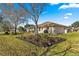 Landscaped backyard with flower beds, trees, and view of neighboring patios at 6188 Sw 84Th St, Ocala, FL 34476