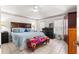 Bright bedroom with beige tile, a ceiling fan, and an upholstered bench at the foot of the bed at 6188 Sw 84Th St, Ocala, FL 34476