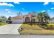 Charming single-story home with a well-manicured lawn, palm tree, and attached two-car garage at 6188 Sw 84Th St, Ocala, FL 34476