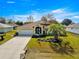 Beautiful single-story home featuring mature landscaping, an American flag, and an attached two-car garage at 6188 Sw 84Th St, Ocala, FL 34476