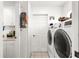 Bright laundry room featuring a modern washer and dryer set, next to storage cabinets at 6188 Sw 84Th St, Ocala, FL 34476