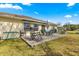 Outdoor patio area with seating, umbrella, and storage box overlooking the manicured lawn in a backyard setting at 6188 Sw 84Th St, Ocala, FL 34476