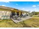 Outdoor patio area with seating, umbrella, and storage box overlooking the manicured lawn in a backyard setting at 6188 Sw 84Th St, Ocala, FL 34476