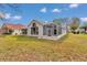 A backyard view highlighting the screened-in lanai, exterior paint and a manicured lawn under a blue sky at 6793 Sw 111Th Loop, Ocala, FL 34476