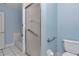 A bathroom showcasing a glass-enclosed shower, toilet, and grab bars for accessibility and safety at 6793 Sw 111Th Loop, Ocala, FL 34476