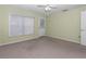 Bedroom with light green walls, neutral carpet, a ceiling fan, and a back door at 6793 Sw 111Th Loop, Ocala, FL 34476