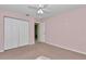 Cozy bedroom featuring carpet flooring, a ceiling fan, and a closet for ample storage at 6793 Sw 111Th Loop, Ocala, FL 34476