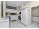 Bright kitchen featuring white cabinets, appliances, and tile flooring, with a ceiling fan providing ventilation at 6793 Sw 111Th Loop, Ocala, FL 34476