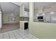 Open-concept kitchen with white cabinetry, light-green walls, and a bar area, seamlessly connected to the living space at 6793 Sw 111Th Loop, Ocala, FL 34476