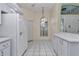 Kitchen nook with white cabinetry, tile flooring, and a window offering natural light near front entrance at 6793 Sw 111Th Loop, Ocala, FL 34476