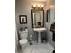 Bathroom with a white pedestal sink, ornate mirror, and marble floors at 8045 Sw 115Th Loop, Ocala, FL 34481