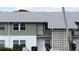 Two-story condo building featuring a pale green and white facade and a light gray shingle roof at 840 Center Ave # 98, Holly Hill, FL 32117