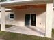 Exterior view of a back patio featuring a stained wood ceiling, ceiling fan, tiled floor, and sliding glass doors at 8498 Sw 129Th Terrace Rd, Dunnellon, FL 34431