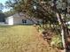 Yard view of home featuring manicured lawn, side of detached garage, and foundation landscaping at 8498 Sw 129Th Terrace Rd, Dunnellon, FL 34431