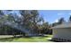 View of side and rear yard of a home, showcasing the lawn and mature tree coverage at 8498 Sw 129Th Terrace Rd, Dunnellon, FL 34431