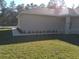 Side view of a home's exterior, highlighting the lush lawn and foundation landscaping at 8498 Sw 129Th Terrace Rd, Dunnellon, FL 34431