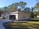 View of the garage with a side entry door, adjacent landscaping and driveway at 8498 Sw 129Th Terrace Rd, Dunnellon, FL 34431