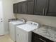 Functional laundry room with washer, dryer, and granite countertops at 8498 Sw 129Th Terrace Rd, Dunnellon, FL 34431