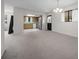 Open living area featuring carpet and light fixtures connecting to a functional kitchen at 8973 Sw 104Th Ln, Ocala, FL 34481