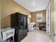 Well-equipped laundry room featuring a large black refrigerator, washer, dryer, sink and ample storage shelving at 9276 Sw 89Th St Rd, Ocala, FL 34481